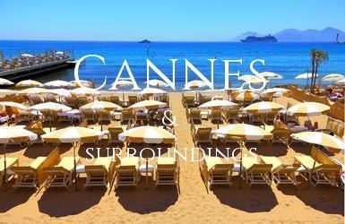 Rows of sun loungers with umbrellas lined up on a private beach looking out to sea at Cannes on the Mediterranean.